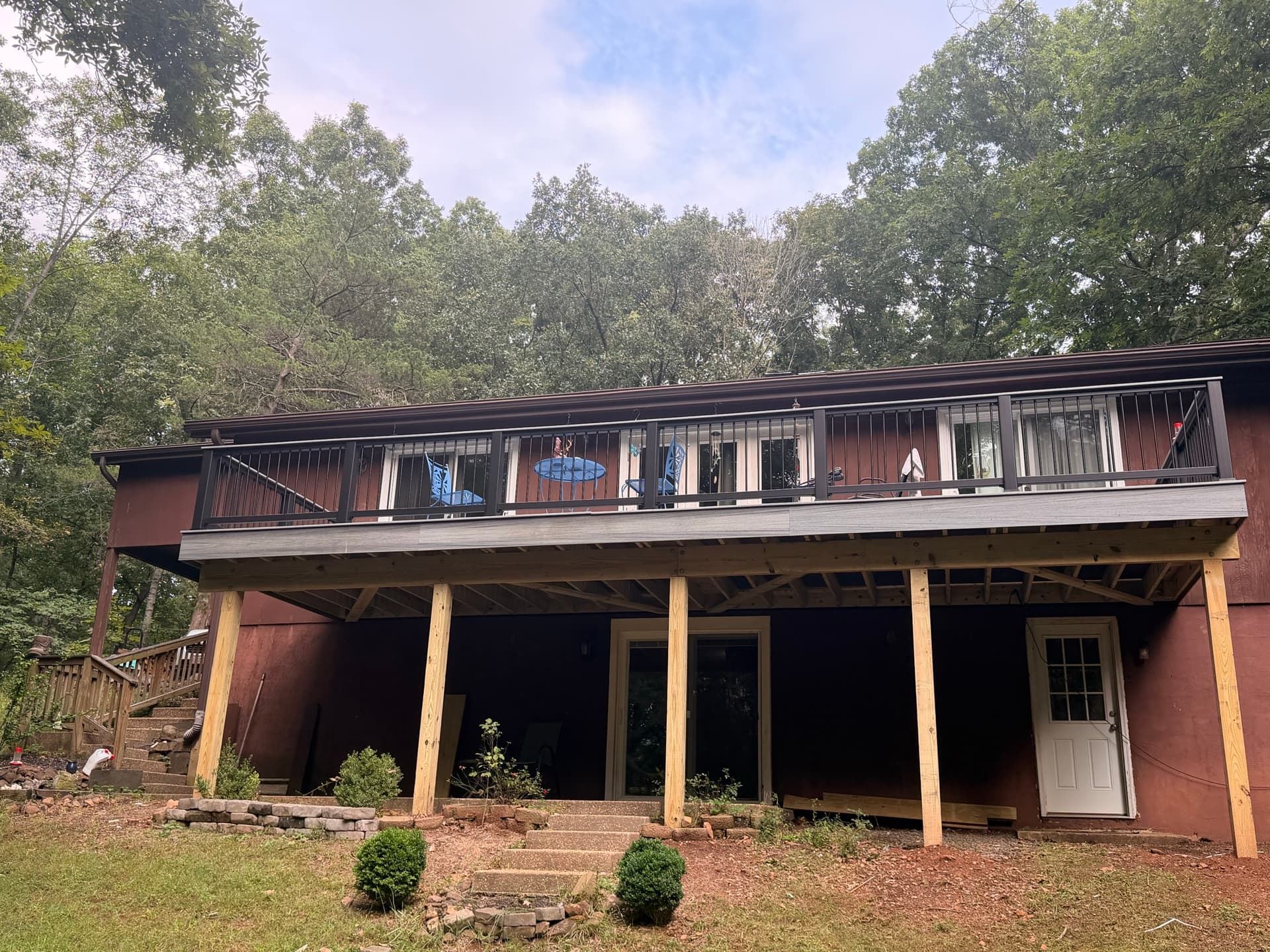 Exterior view of the Gainesville deck showing matching gray fascia and black railings against the house.